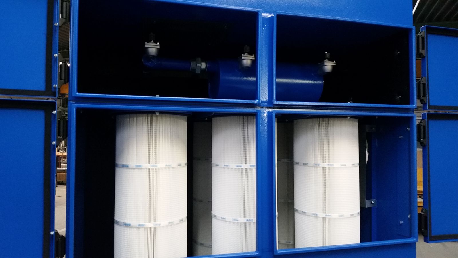 Geöffnete Filteranlage mit drei Filterpatronen und den Ventilen der Druckluftabreinigung